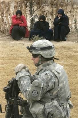 Women watch as U.S. army soldiers from Ghostrider Company, 3rd ...