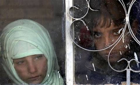 Children watch as U.S. army soldiers from Ghostrider Company, ...